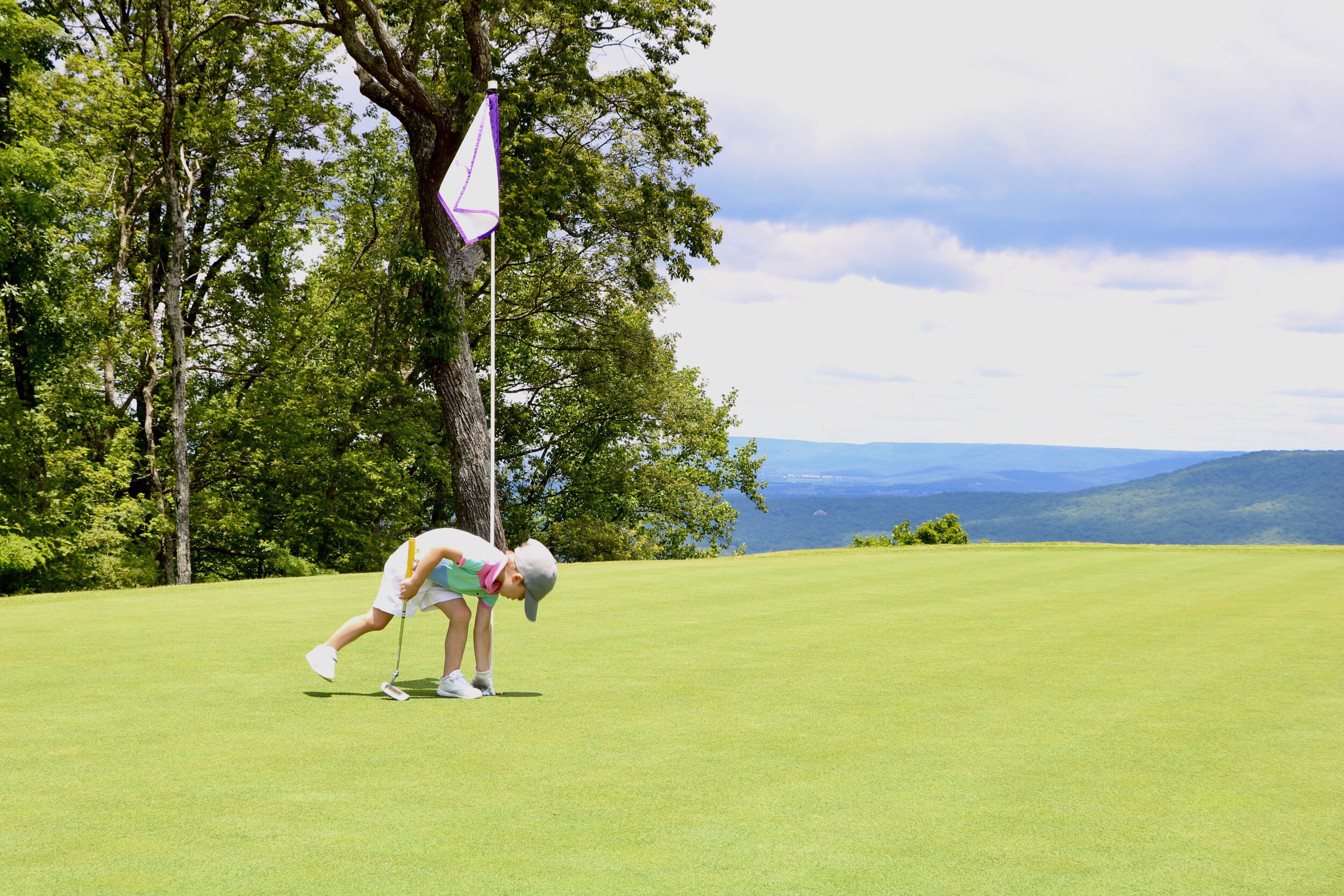 Jack grabbing his ball out of the hole on the infinity-edge third green at Sewanee.