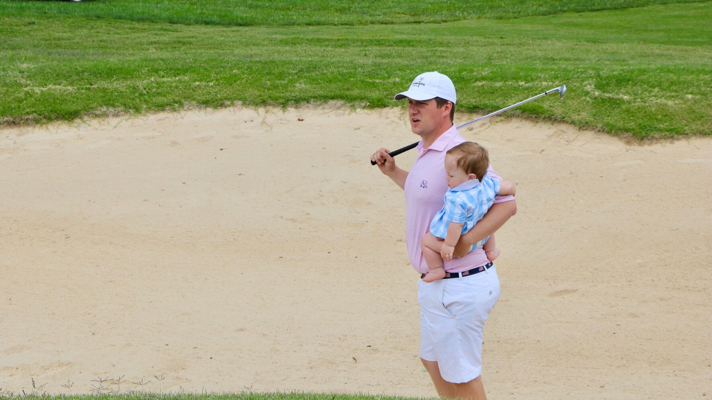 Joseph holding his youngest son, Teddy, moments before an up and down on the eighth.